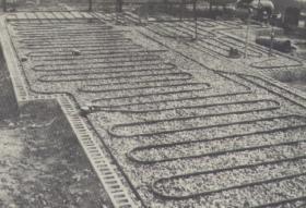 Hydronic radiant floor panel system being installed in the 1940s