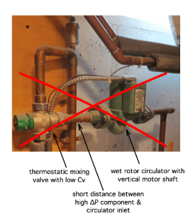 A thermostatic mixing valve with a low Cv value is located just upstream of the circulator.