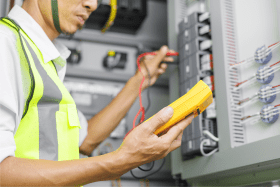 A person testing an electrical unit.