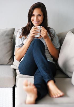 Woman sitting on couch barefoot