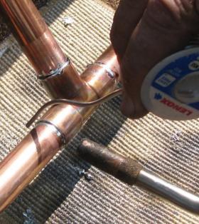 A copper tubing joined to a tee fitting using soft soldering.